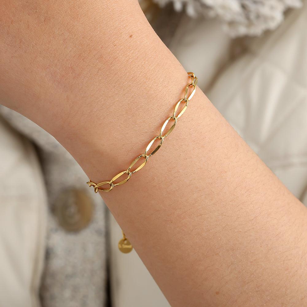 Goudkleurige Luna Bracelet van RVS met ovale schakels gedragen om een pols.