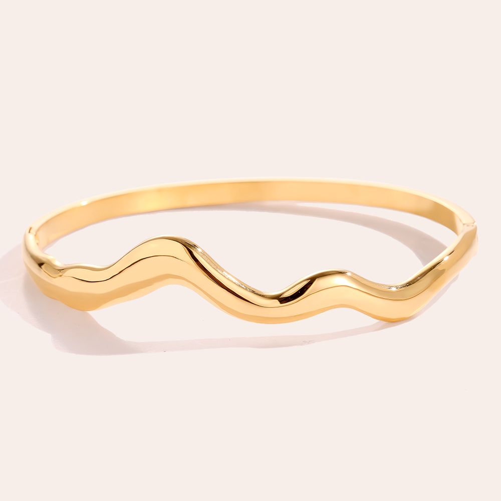 Wave bangle goudkleurig RVS. Moderne en organische sieraden.