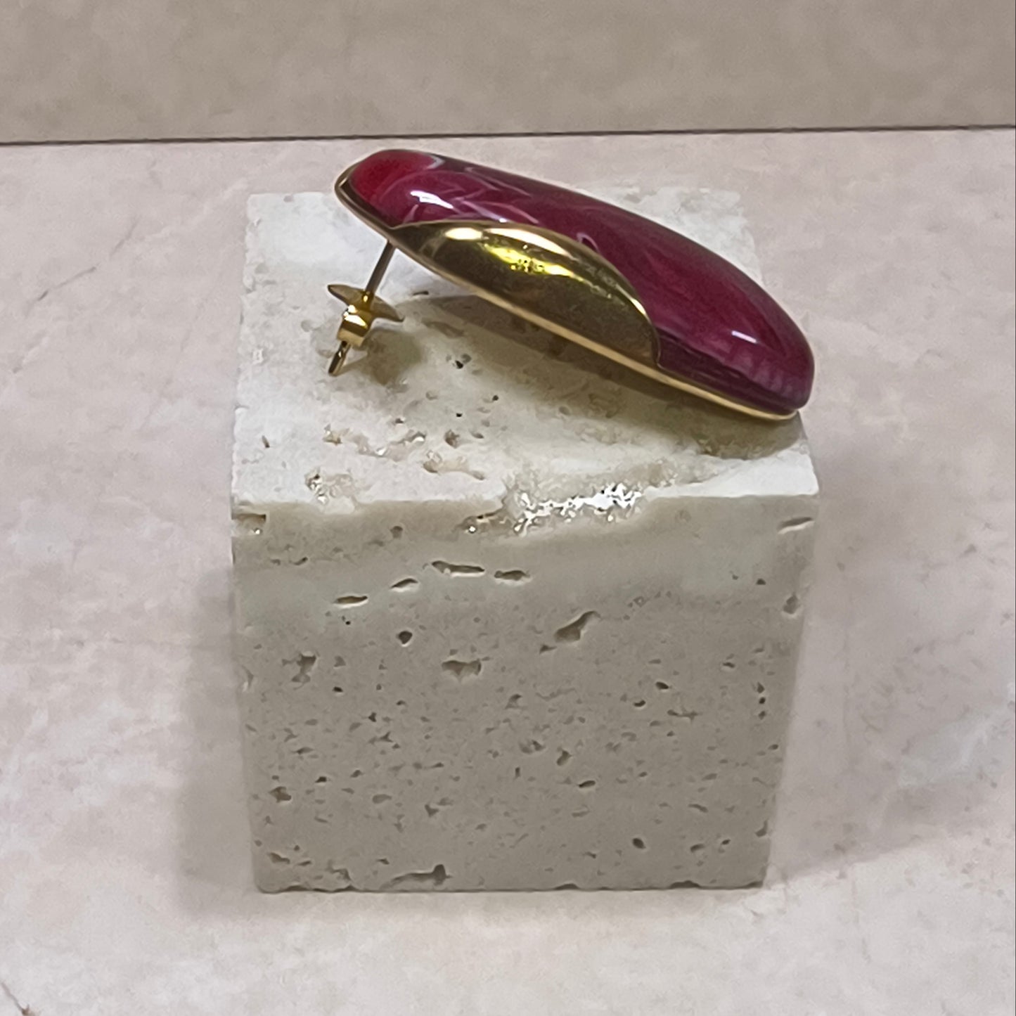 The Crimson oorbel van hars en RVS in dieprode kleur. Zijkant van het oorknopje.