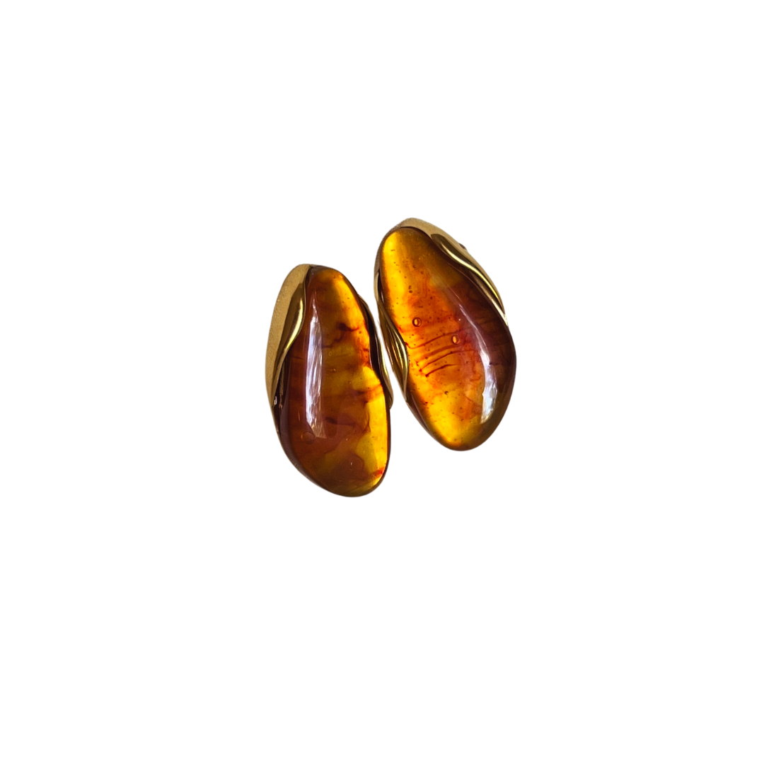 Goudkleurige oorbellen met amberkleurige harssteen in organische vorm