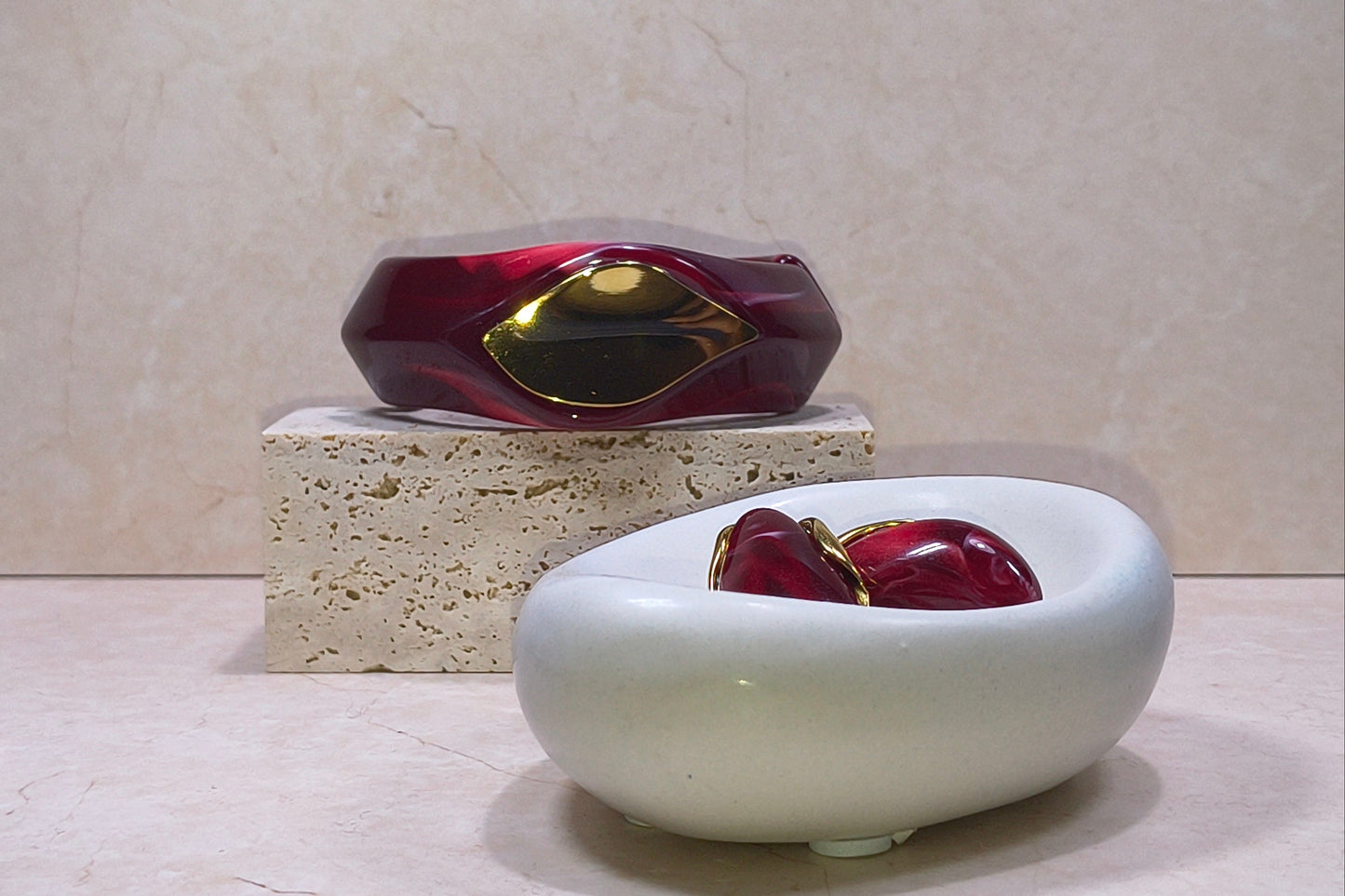 The Crimson set bestaande uit een bangle en bijpassende set oorbellen van hars en RVS in een dieprode kleur met gouden accenten.