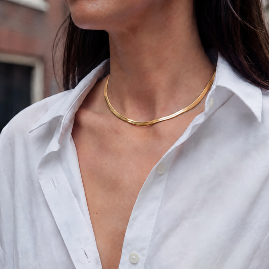 Vrouw draagt de Snake Chain 5 mm goudkleurige RVS ketting. Minimalistische waterproof ketting met brede snake chain voor een tijdloze everyday look.
