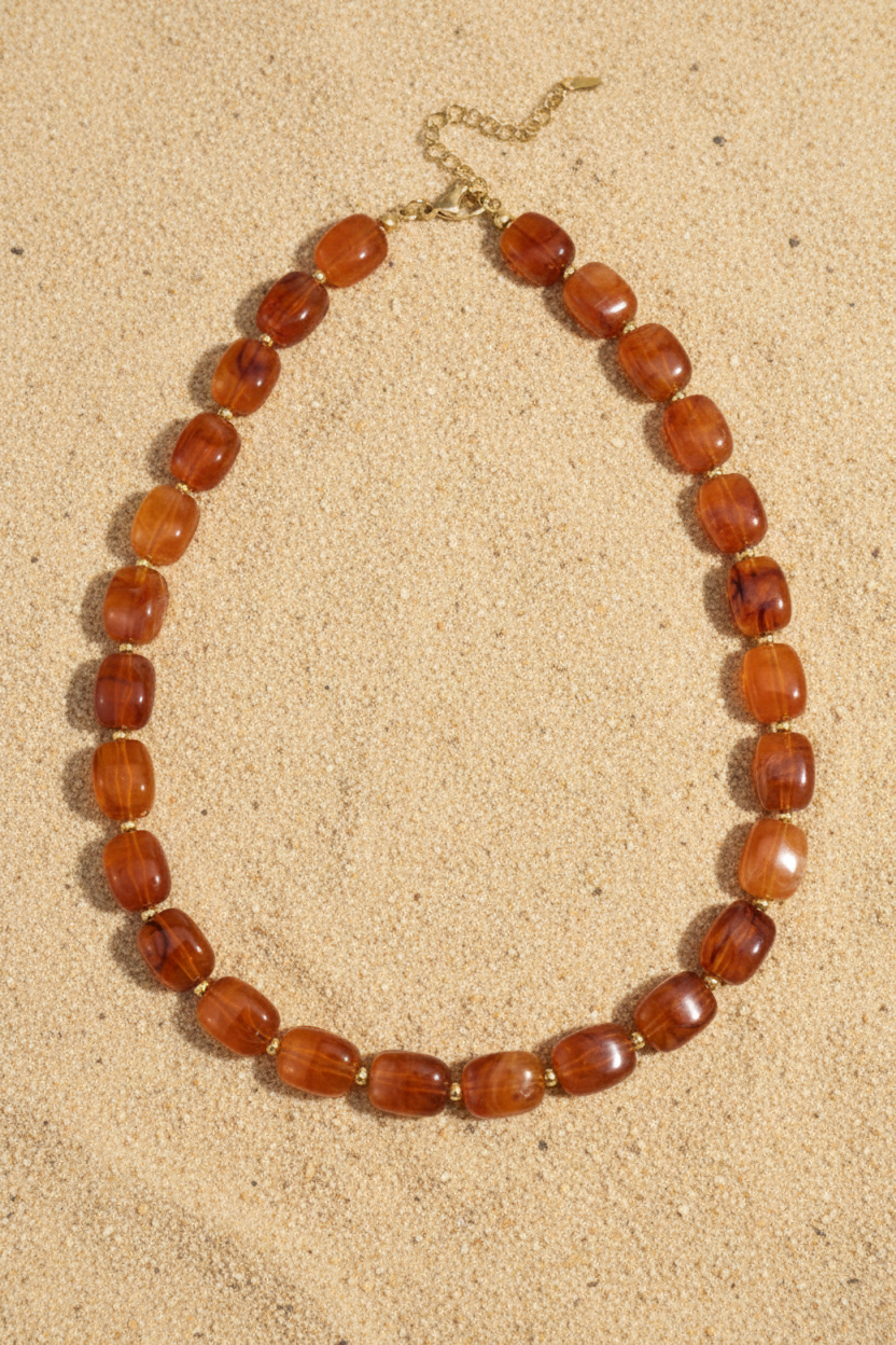 Amber kralenketting op zand – Pinterest productfoto