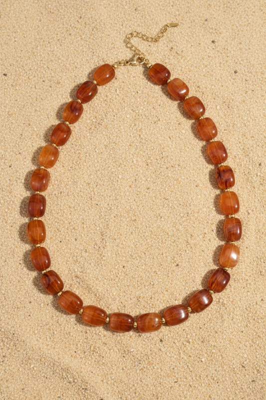 Amber kralenketting op zand – Pinterest productfoto