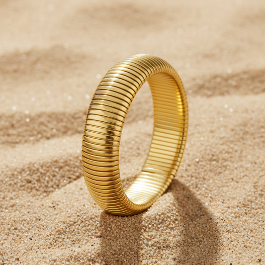 Gouden flex armband met ribbels op zand – Pinterest productfoto